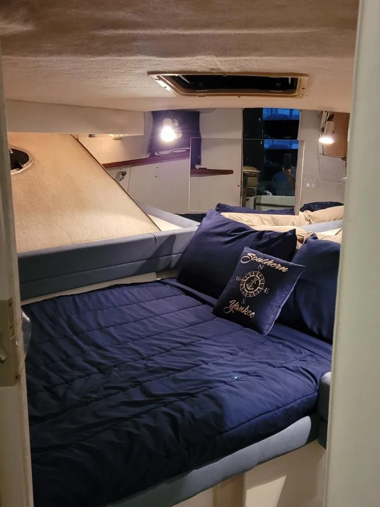 Slide: The Image of Cozy cabin interior of 1992 Carver Command Bridge 28 with blue bedding and nautical decor. - 24