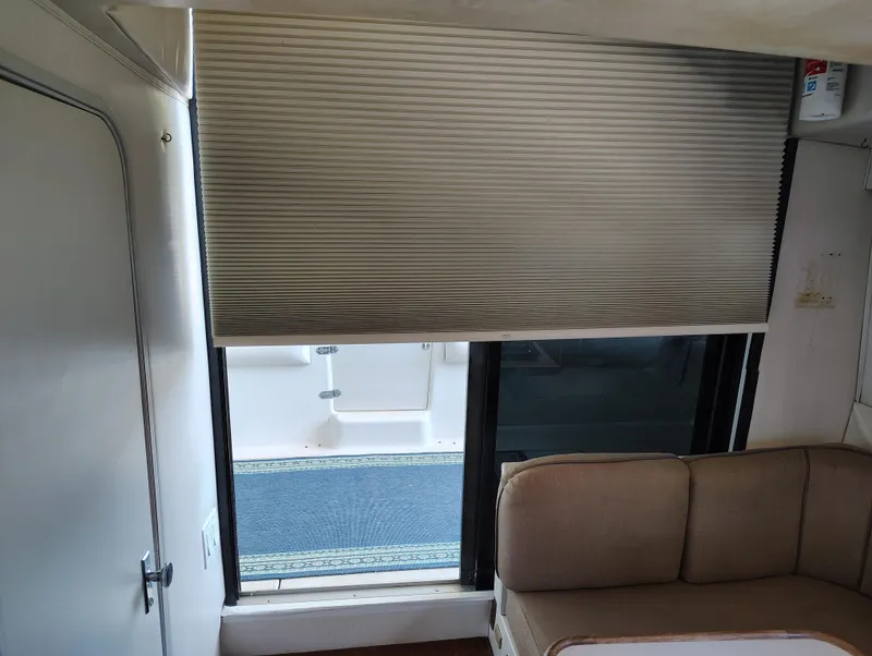 Slide: The Image of Interior of 1992 Carver Command Bridge 28 with window blinds and seating area. - 25