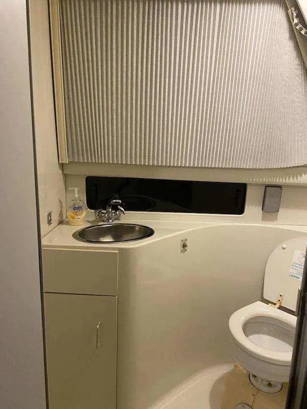 Slide: The Image of Bathroom interior of 1992 Carver Command Bridge 28 boat, featuring sink and toilet. - 29