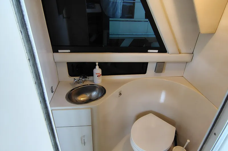 Slide: The Image of 1992 Carver Command Bridge 28 boat bathroom with sink, toilet, and window. - 30