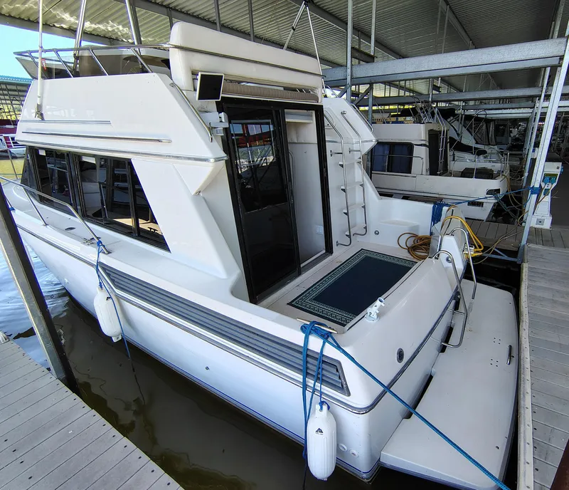 Slide: The Image of 1992 Carver Command Bridge 28 docked in a marina, featuring a spacious deck and modern design. - 7