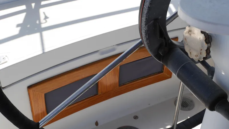 Slide: The Image of Steering wheel and cockpit of 1986 Ericson 35 MKIII sailboat, featuring wooden accents. - 16