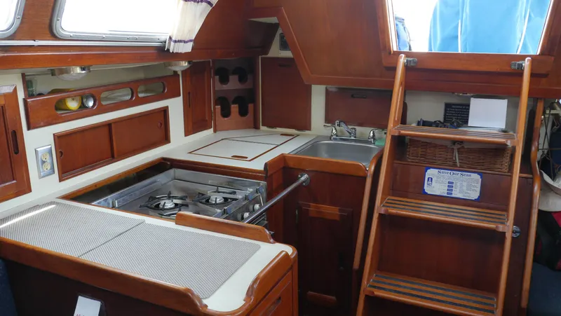 Slide: The Image of 1986 Ericson 35 MKIII yacht interior with wooden cabinetry and compact kitchen area. - 18