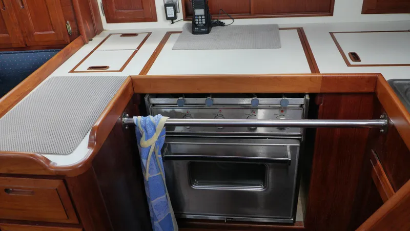 Slide: The Image of 1986 Ericson 35 MKIII yacht kitchen with stainless steel oven and wooden cabinetry. - 19