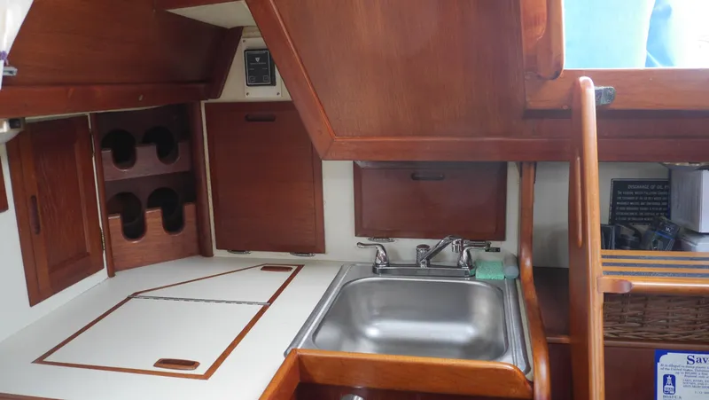 Slide: The Image of 1986 Ericson 35 MKIII yacht galley with wooden cabinetry and stainless steel sink. - 23