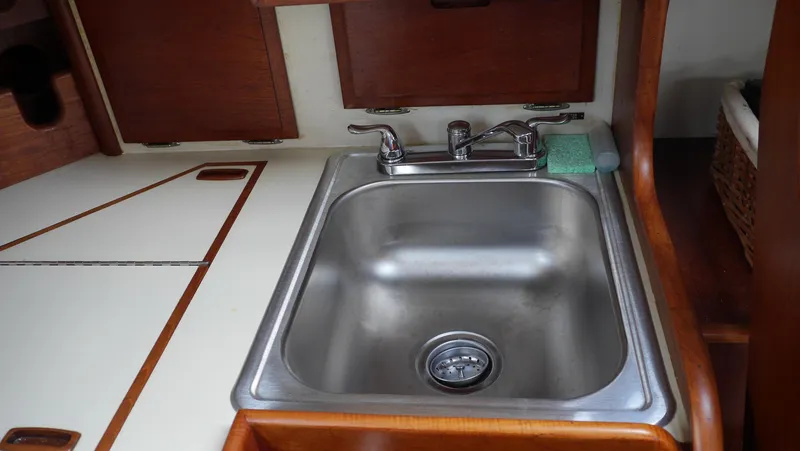 Slide: The Image of Stainless steel sink in 1986 Ericson 35 MKIII yacht galley with wooden cabinetry. - 24
