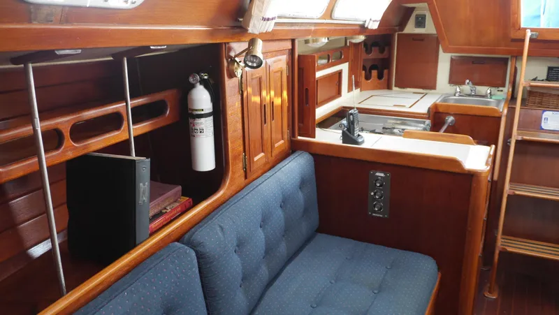 Slide: The Image of Interior of 1986 Ericson 35 MKIII sailboat with wooden cabinetry and blue cushioned seating. - 25