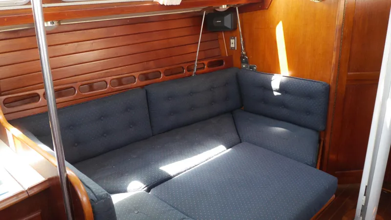 Slide: The Image of Interior of 1986 Ericson 35 MKIII sailboat with blue cushioned seating and wooden paneling. - 28