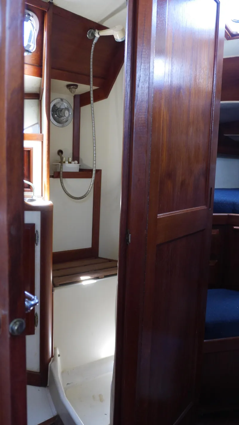 Slide: The Image of 1986 Ericson 35 MKIII yacht interior with wooden cabinetry and compact shower area. - 30