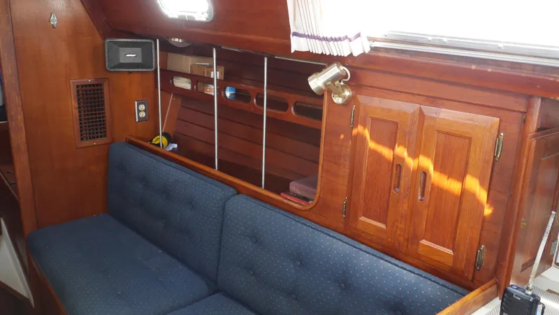 Slide: The Image of Interior of 1986 Ericson 35 MKIII sailboat with wooden cabinetry and blue cushioned seating. - 34