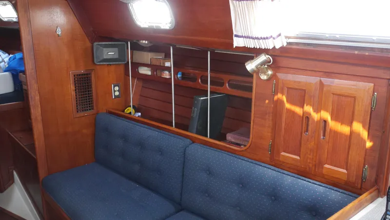 Slide: The Image of Interior of 1986 Ericson 35 MKIII sailboat with blue cushioned seating and wooden cabinetry. - 35