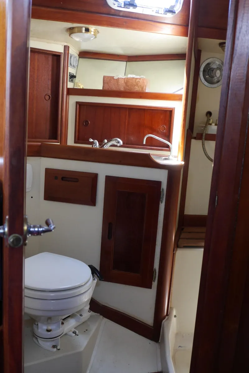 Slide: The Image of 1986 Ericson 35 MKIII yacht bathroom with wooden cabinetry and white fixtures. - 36