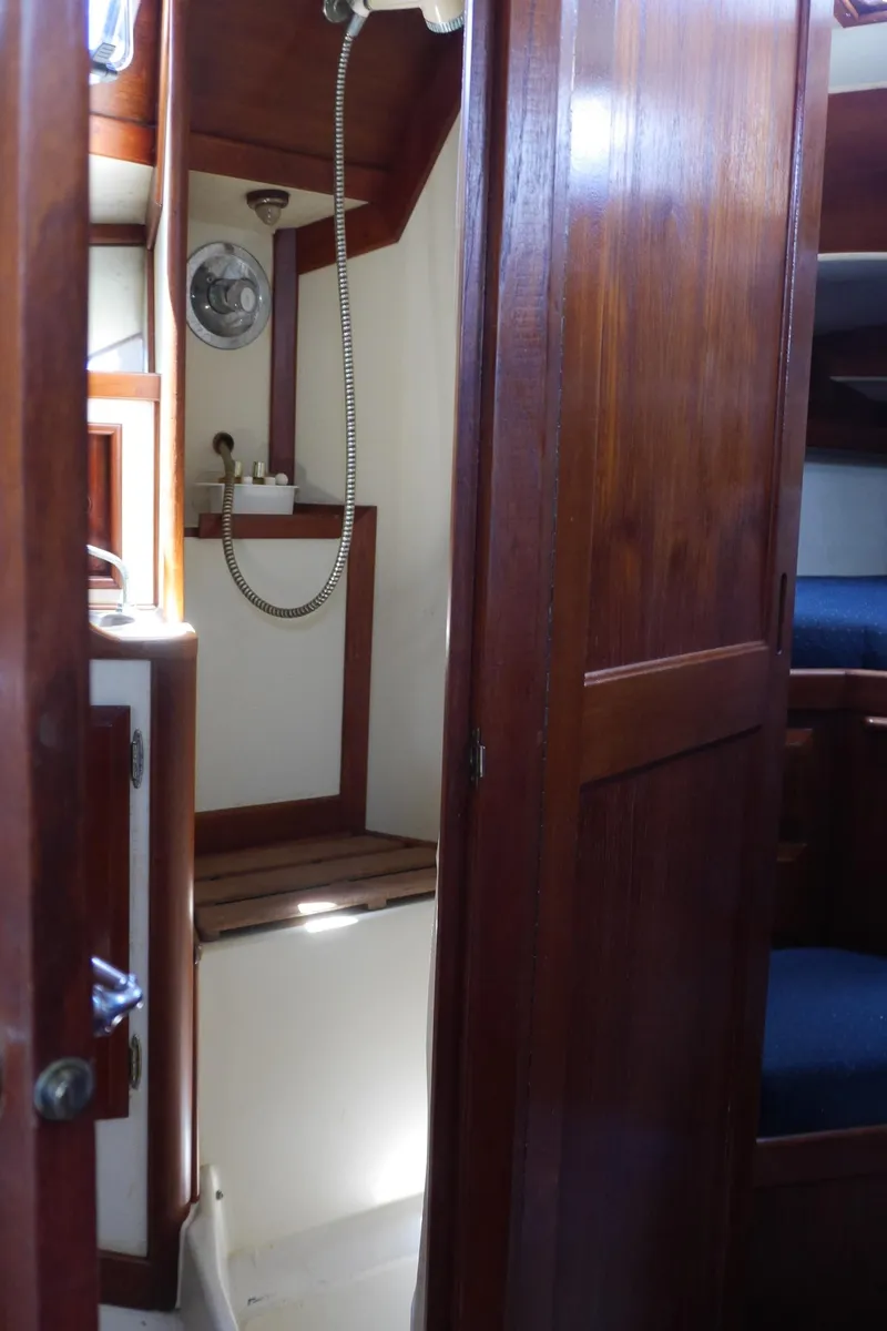 Slide: The Image of 1986 Ericson 35 MKIII yacht interior with wooden cabinetry and compact shower area. - 37