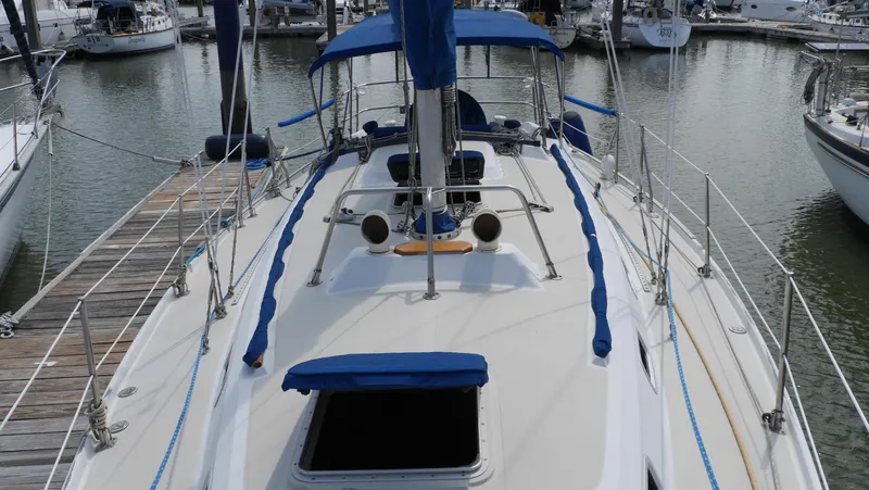 Slide: The Image of 1986 Ericson 35 MKIII sailboat docked in marina, featuring blue accents and open hatch. - 4