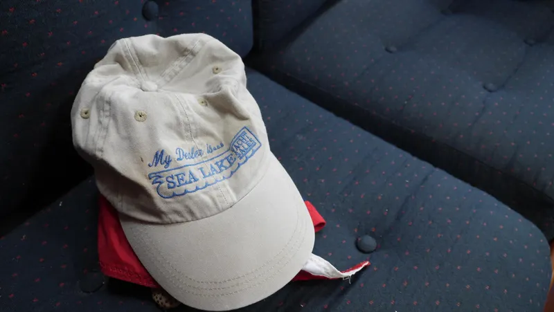 Slide: The Image of A beige cap with "My Other Car is a Sea Lake Yacht" text on a blue cushioned seat. - 41