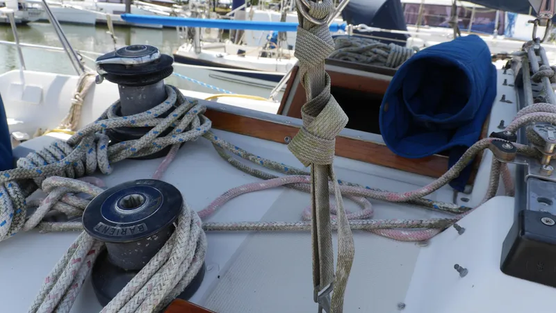 Slide: The Image of 1986 Ericson 35 MKIII sailboat deck with ropes and winches in a marina. - 8