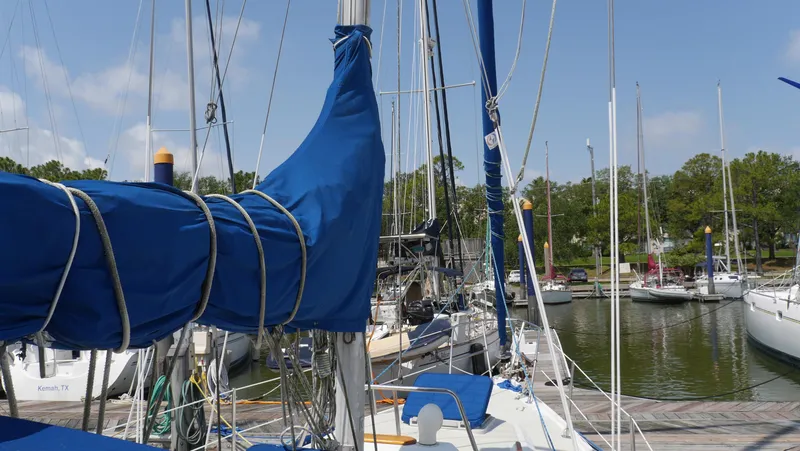 Slide: The Image of Sailboats docked at a marina, featuring a 1986 Ericson 35 MKIII with blue sail covers. - 9