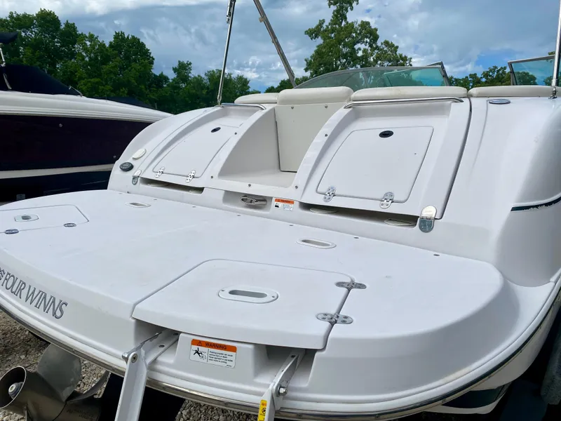 Slide: The Image of 2005 Four Winns 234 Funship boat with spacious deck and storage compartments. - 19