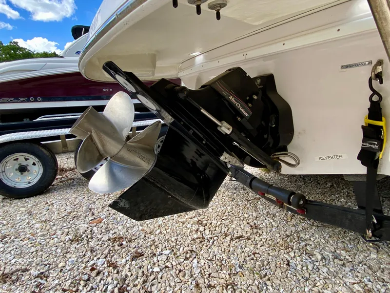 Slide: The Image of 2005 Four Winns 234 Funship boat propeller and stern on gravel surface. - 20