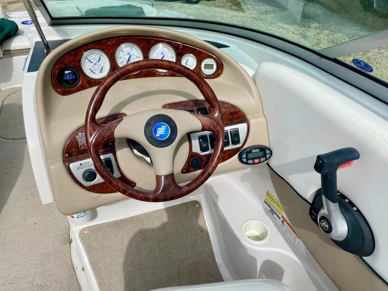Slide: The Image of 2005 Four Winns 234 Funship boat dashboard with wood accents and steering wheel. - 9