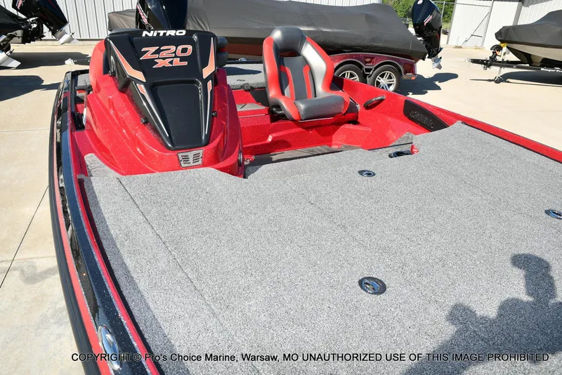 Slide: The Image of 2025 Nitro Z20 XL Pro boat with red and gray interior, parked outdoors. - 35
