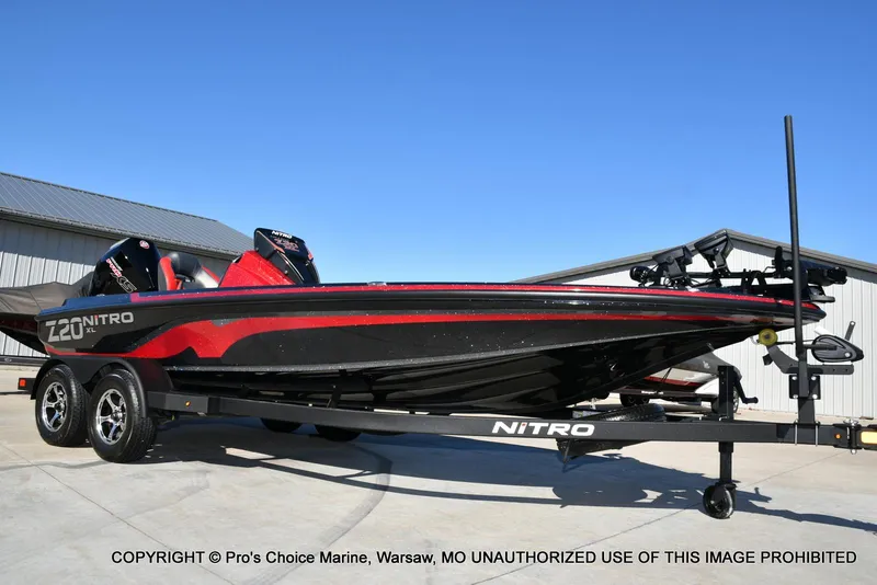 Slide: The Image of 2025 Nitro Z20 XL Pro boat on trailer, black and red design, parked outdoors. - 79