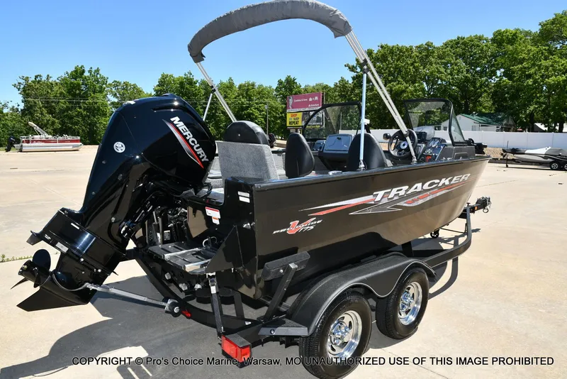 Slide: The Image of 2023 Tracker Pro Guide V-175 Combo boat with Mercury engine on trailer, outdoors. - 17