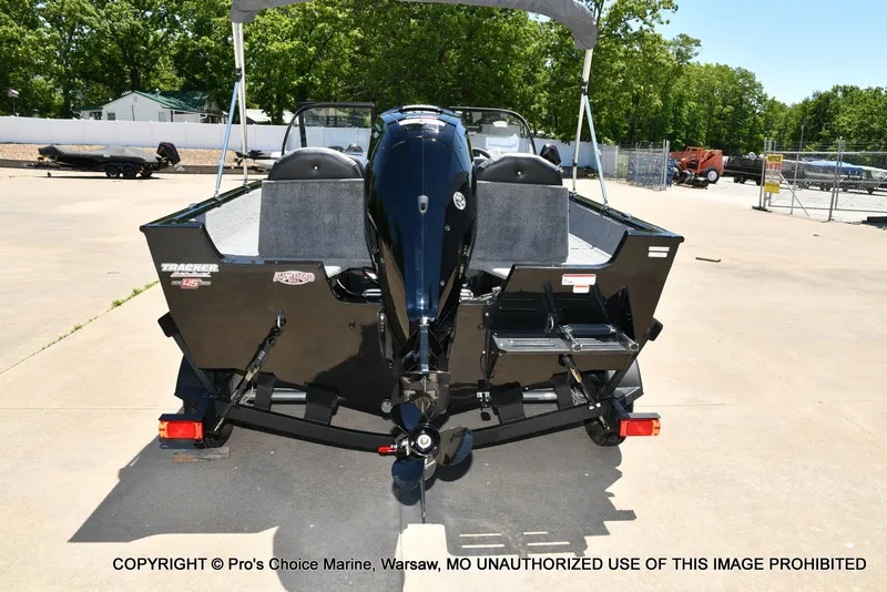 Slide: The Image of 2023 Tracker Pro Guide V-175 Combo boat, rear view, parked outdoors on a sunny day. - 25