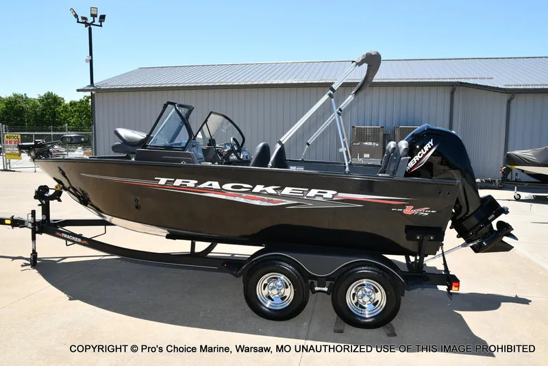 Slide: The Image of 2023 Tracker Pro Guide V-175 Combo boat on trailer, parked outdoors. - 27