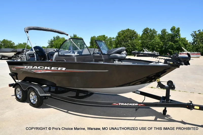 Slide: The Image of 2023 Tracker Pro Guide V-175 Combo boat on trailer, parked outdoors. - 81