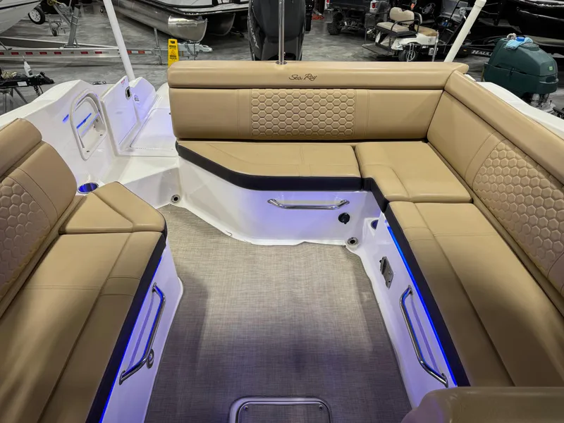 Slide: The Image of 2018 Sea Ray 270 SDX boat interior with tan seating and blue accent lighting. - 11
