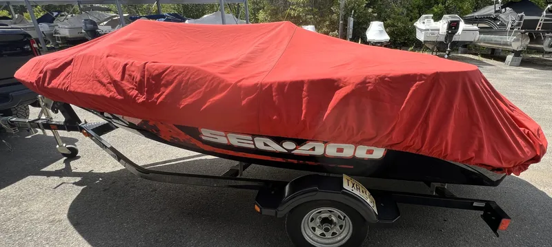 Slide: The Image of 2011 Sea-Doo 150 Speedster covered with a red tarp on a trailer. - 2