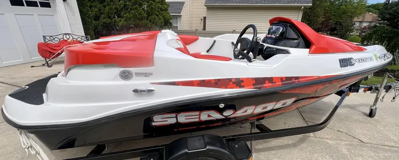 Slide: The Image of 2011 Sea-Doo 150 Speedster boat with red and white design on a trailer. - 8