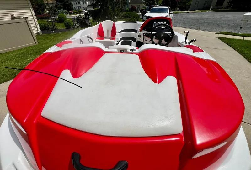 Slide: The Image of 2011 Sea-Doo 150 Speedster boat with red and white seating, parked on a driveway. - 9