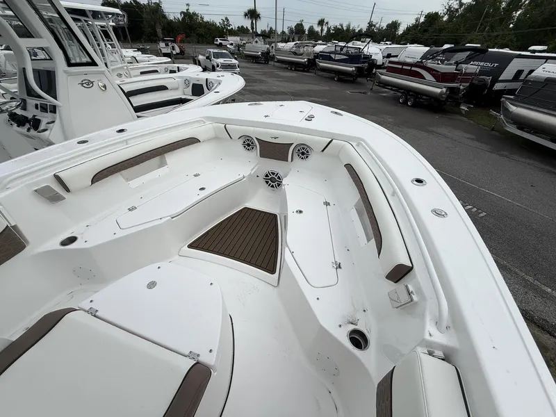 Slide: The Image of 2025 Tidewater 272 LXF boat interior with seating and storage, displayed in a marina. - 7