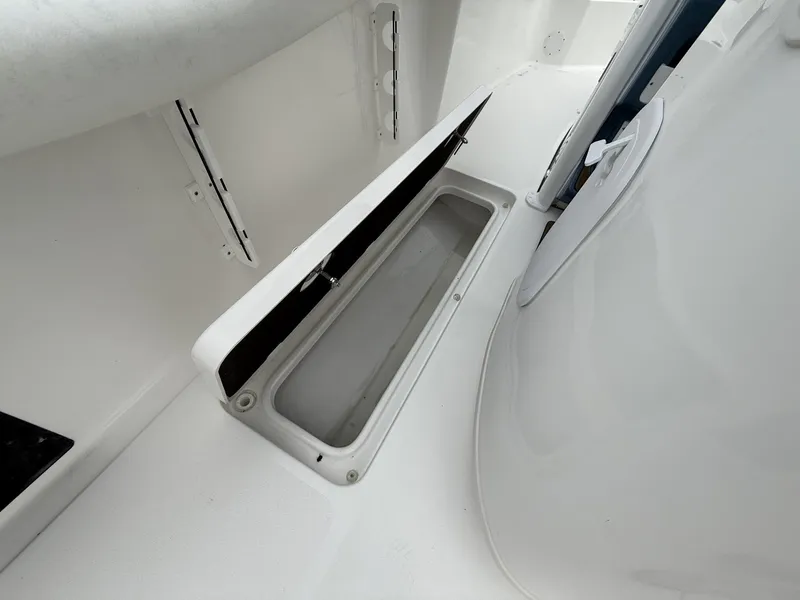 Slide: The Image of 2025 Tidewater 272 LXF boat storage compartment with open lid, showcasing interior space. - 9