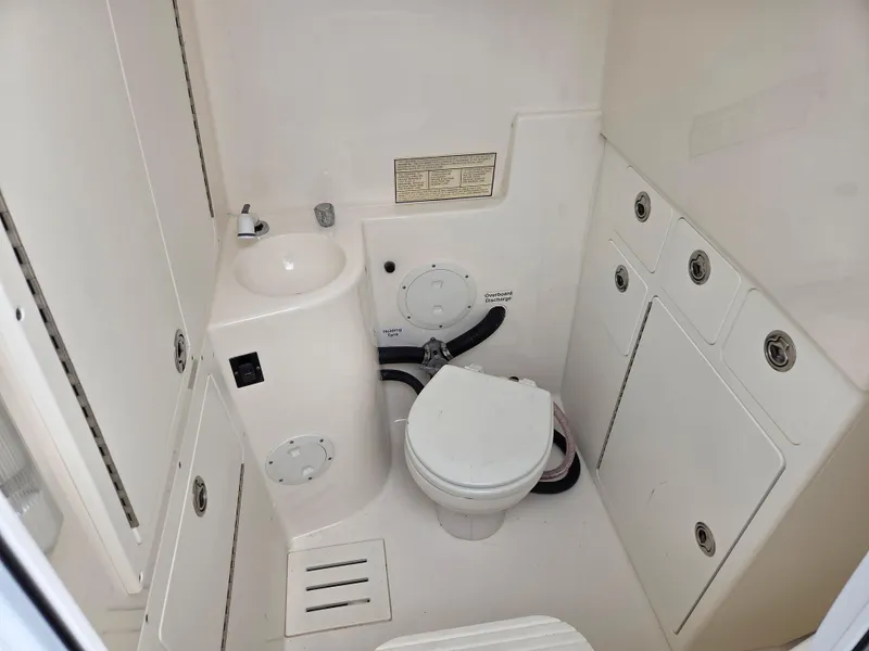 Slide: The Image of 2005 Regulator 32 Forward Seating boat bathroom with compact toilet and sink. - 11