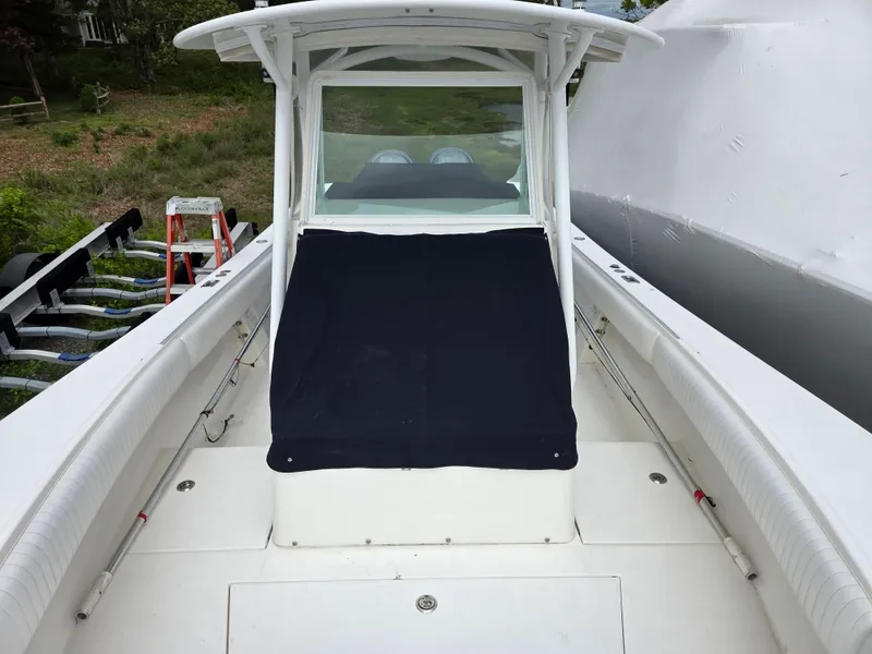 Slide: The Image of 2005 Regulator 32 Forward Seating boat with covered console, docked outdoors. - 13