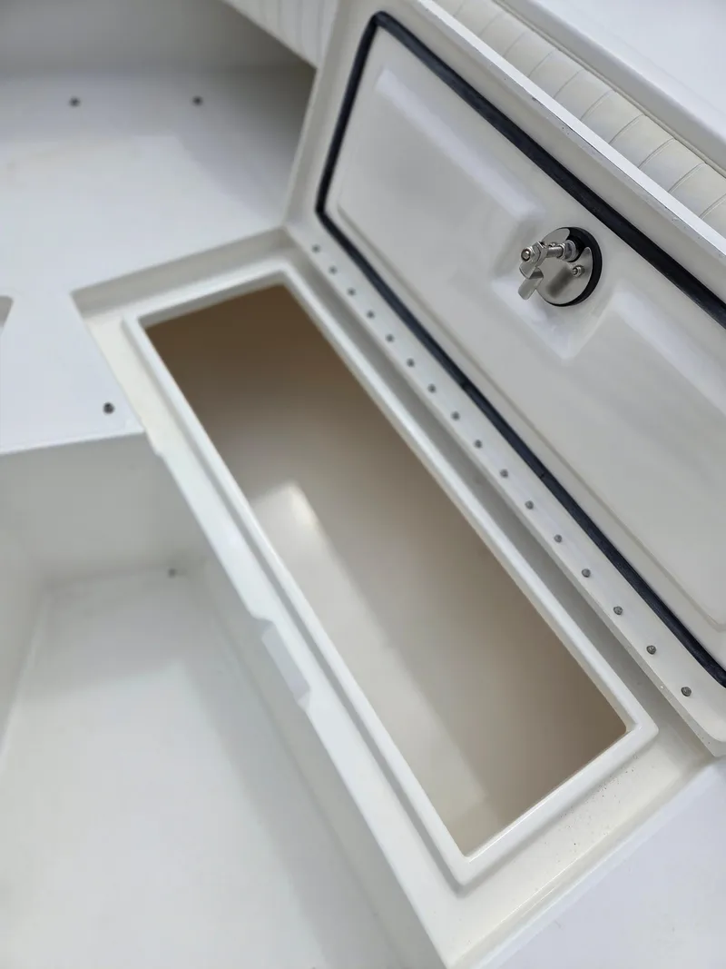 Slide: The Image of 2005 Regulator 32 Forward Seating storage compartment, open and empty, with secure latch. - 14