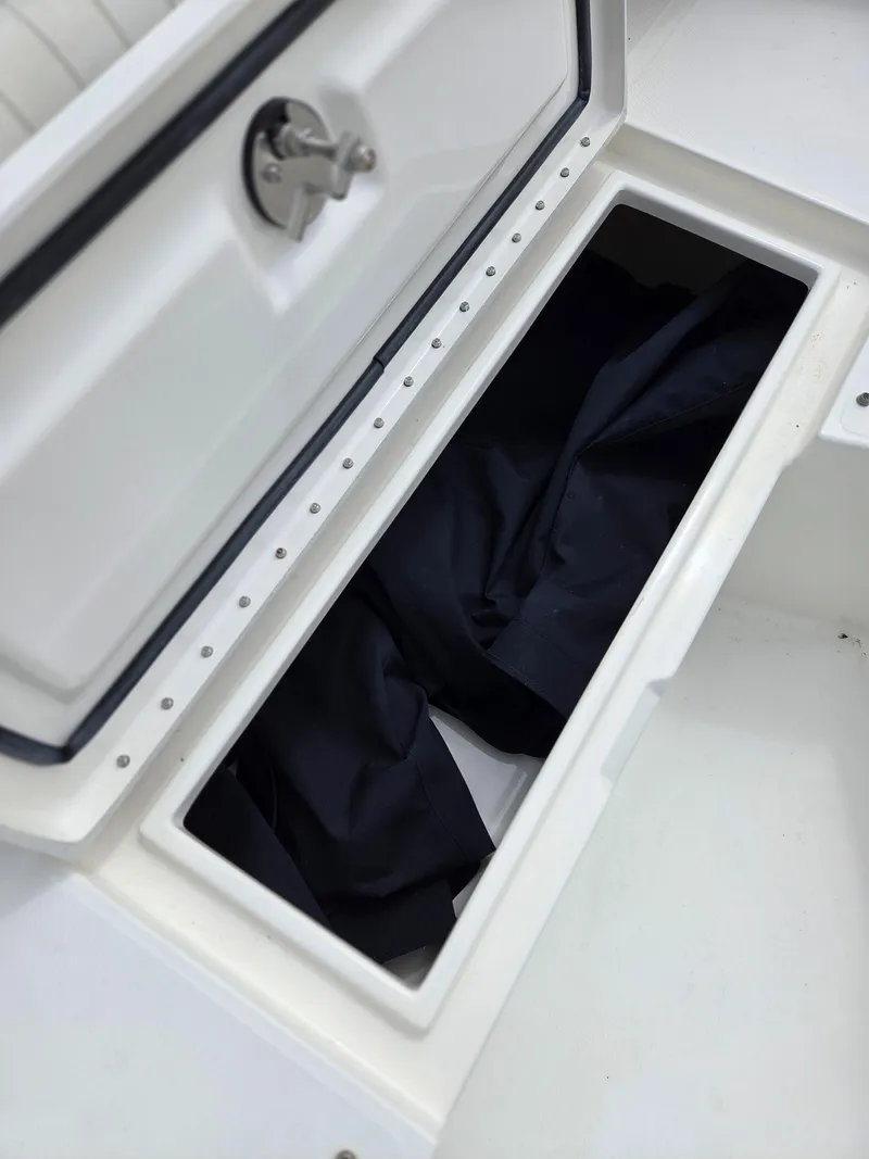 Slide: The Image of Storage compartment on 2005 Regulator 32 Forward Seating boat, open with dark fabric inside. - 15