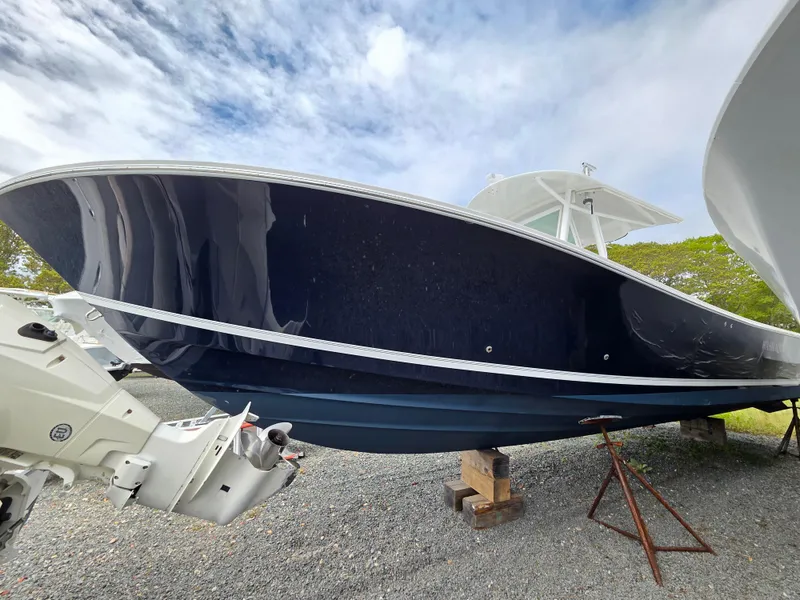 Slide: The Image of 2005 Regulator 32 Forward Seating boat on display, blue hull, outboard engines visible. - 3