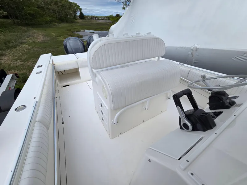 Slide: The Image of 2005 Regulator 32 Forward Seating boat interior with white cushioned seats and control panel. - 8