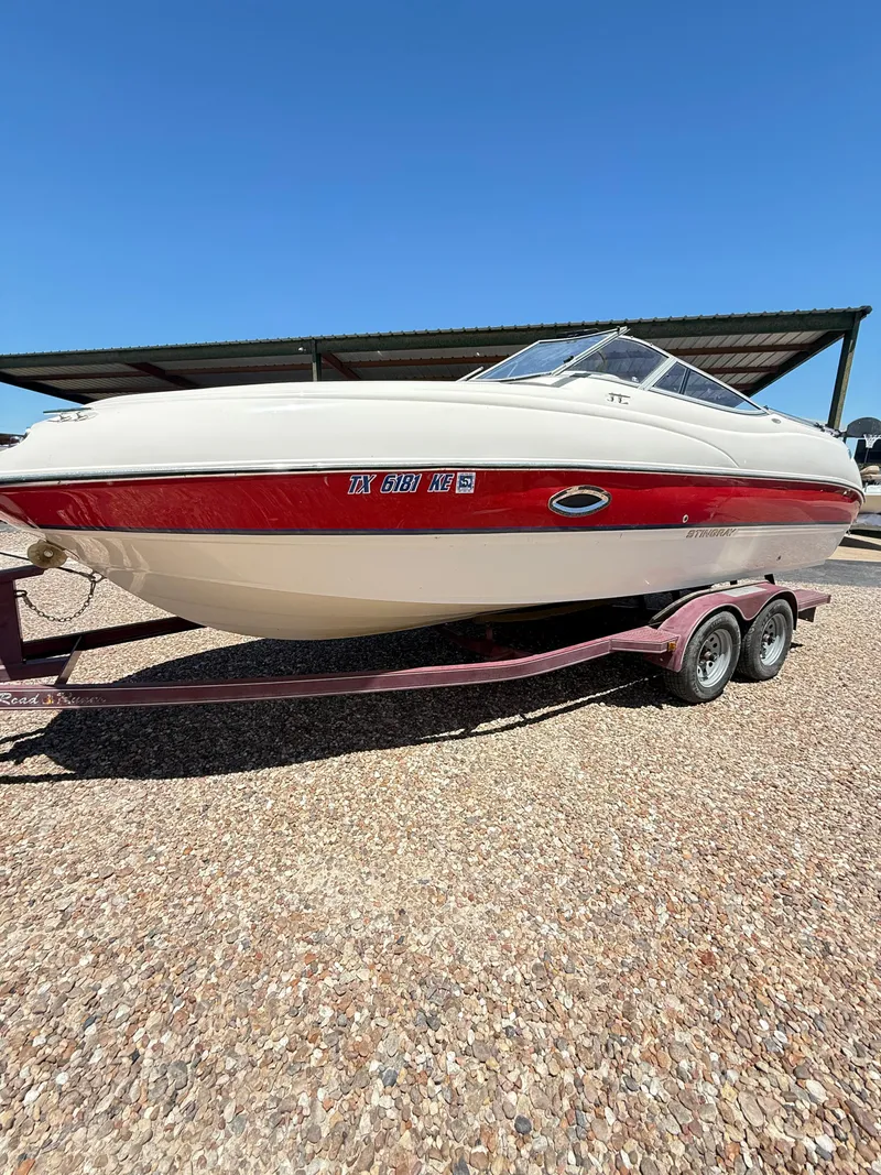 Slide: The Image of 2005 Stingray 220 DR boat on trailer under clear blue sky. - 1