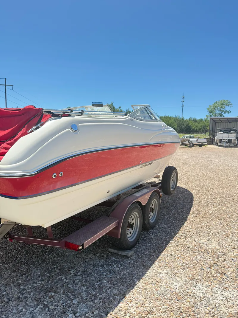 Slide: The Image of 2005 Stingray 220 DR boat on trailer, red and white design, sunny day. - 2
