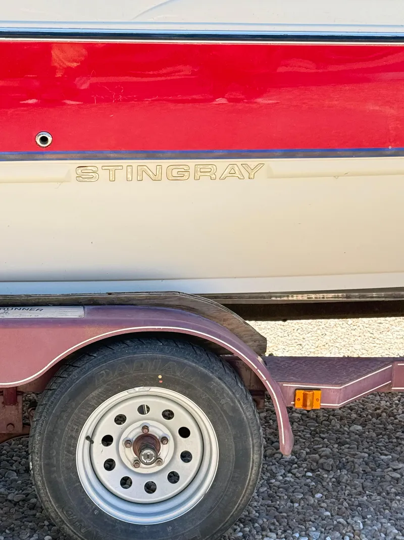 Slide: The Image of 2005 Stingray 220 DR boat on trailer, red and white exterior. - 6