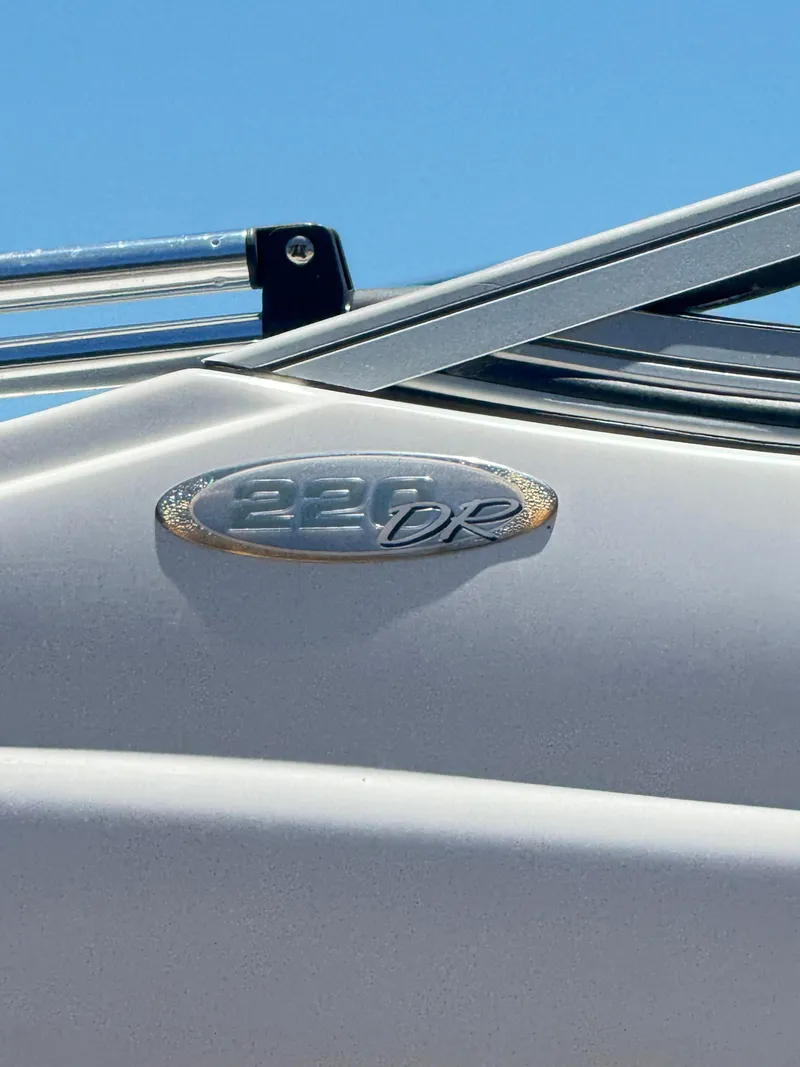 Slide: The Image of Close-up of 2005 Stingray 220 DR boat emblem under clear blue sky. - 7