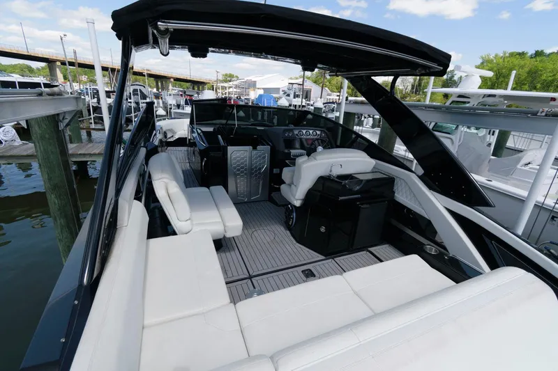 Slide: The Image of 2020 Cruisers Yachts 338 SS OB with spacious seating and sleek design at a marina. - 10