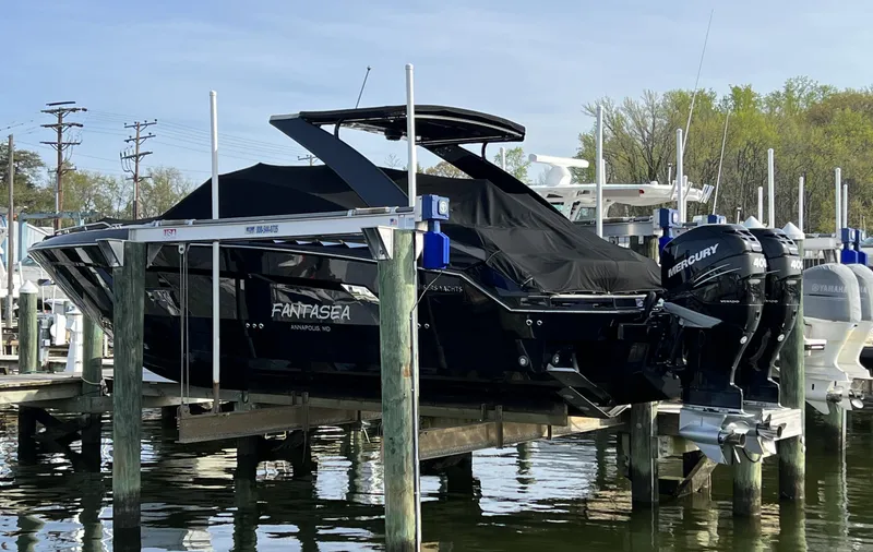 Slide: The Image of 2020 Cruisers Yachts 338 SS OB on lift, covered, docked at marina. - 3