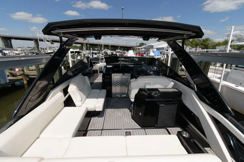 Slide: The Image of 2020 Cruisers Yachts 338 SS OB with spacious seating and sleek design at a marina. - 4