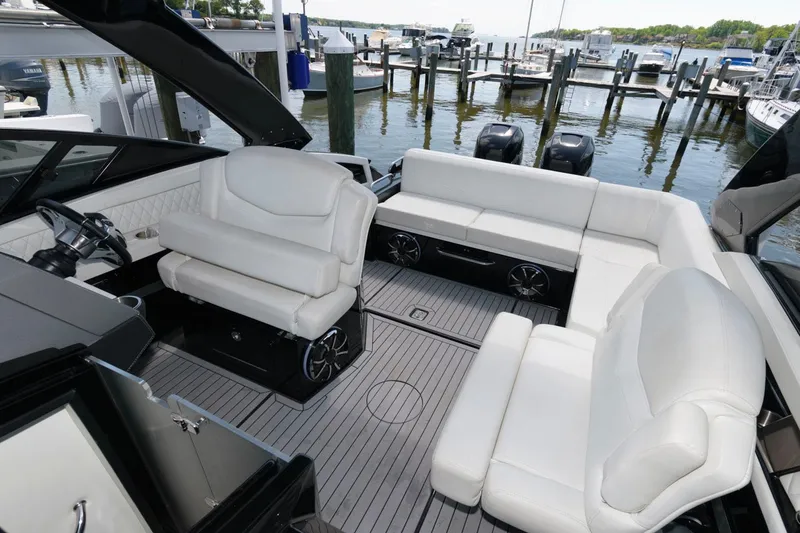 Slide: The Image of 2020 Cruisers Yachts 338 SS OB interior with white seating, docked at marina. - 8